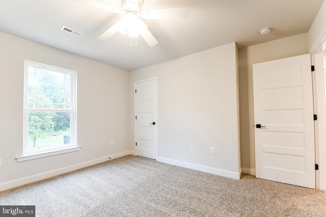 unfurnished bedroom featuring multiple windows, ceiling fan, and light colored carpet