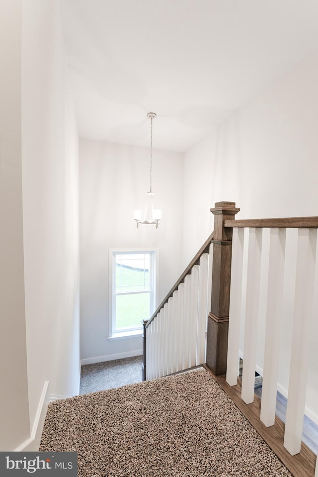 stairway with a chandelier and light wood-type flooring