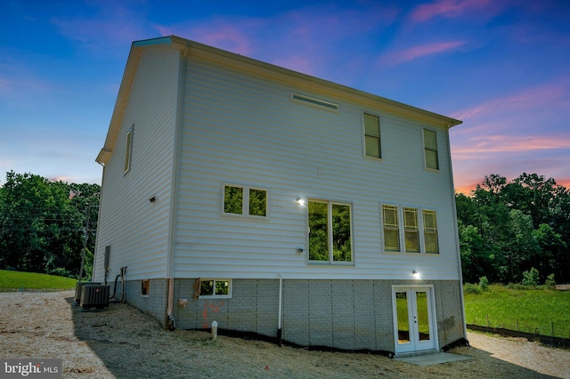 back house at dusk featuring central AC and french doors