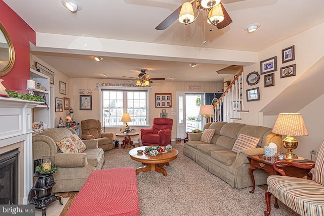 living room featuring beam ceiling, ceiling fan, and light colored carpet