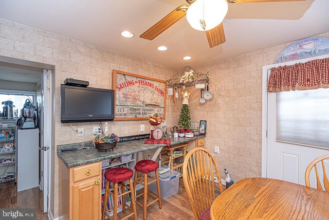 kitchen with dark stone counters, dark hardwood / wood-style floors, ceiling fan, and light brown cabinetry