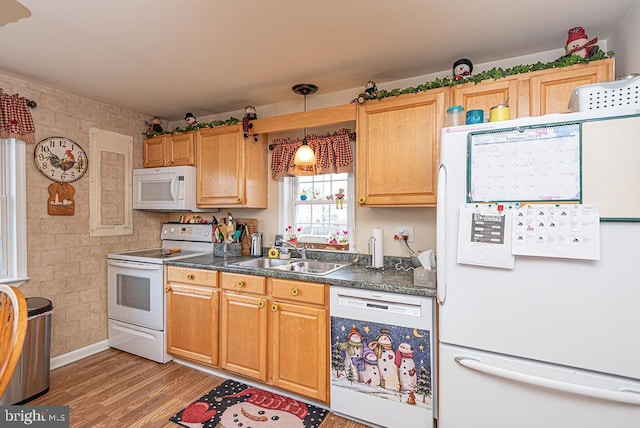 kitchen featuring sink, white appliances, light hardwood / wood-style floors, and decorative light fixtures