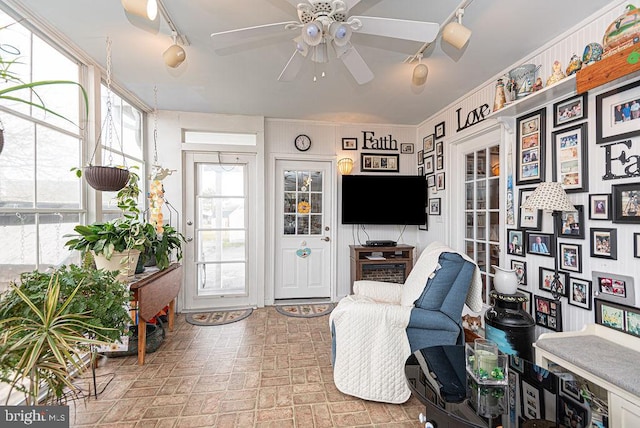 interior space with track lighting, crown molding, ceiling fan, and a wealth of natural light