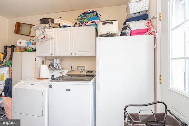 laundry area with washing machine and dryer and cabinets