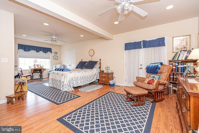 bedroom featuring ceiling fan, light wood-type flooring, and beam ceiling