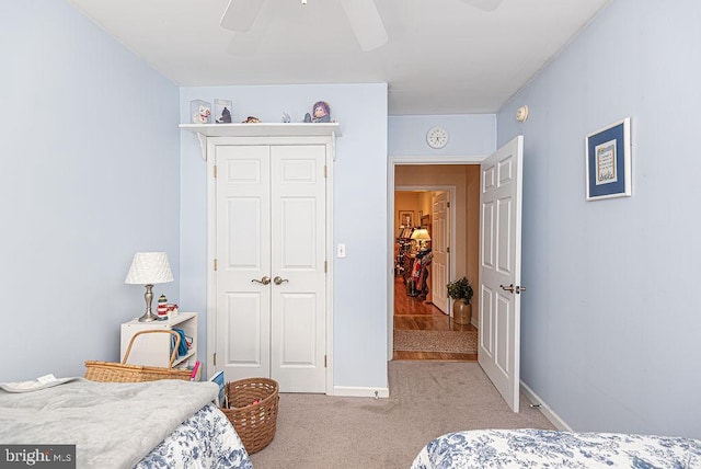 carpeted bedroom with ceiling fan and a closet