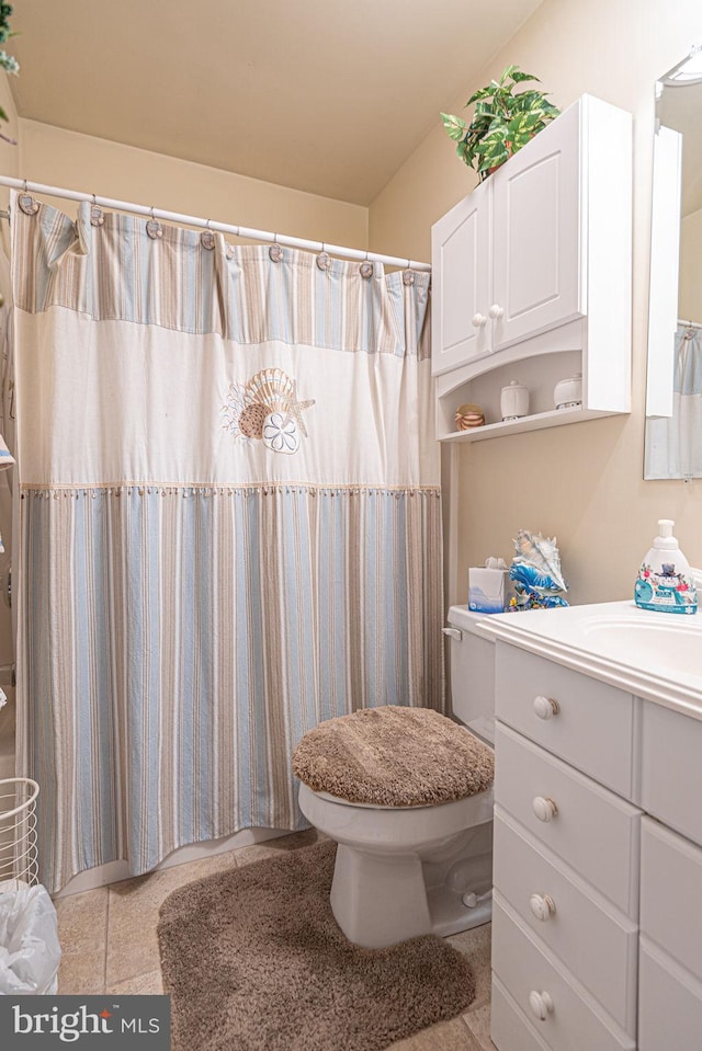 bathroom with tile floors, toilet, and vanity