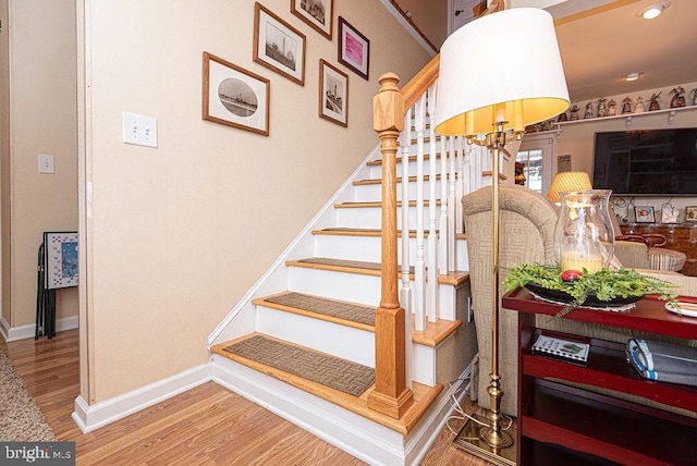 stairway with an inviting chandelier and hardwood / wood-style floors