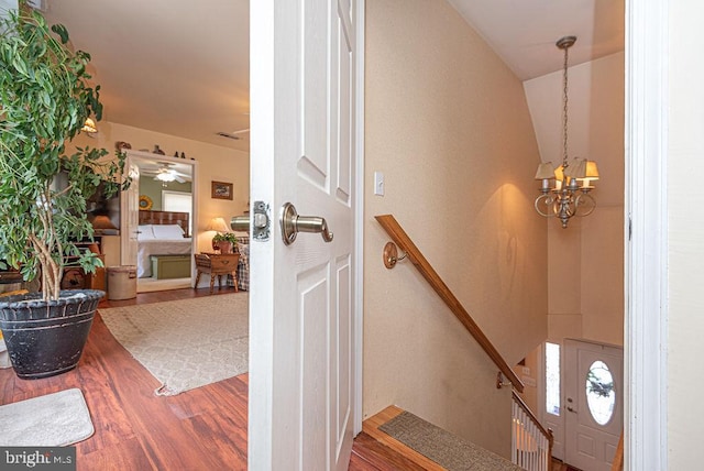 interior space with hardwood / wood-style floors and ceiling fan with notable chandelier