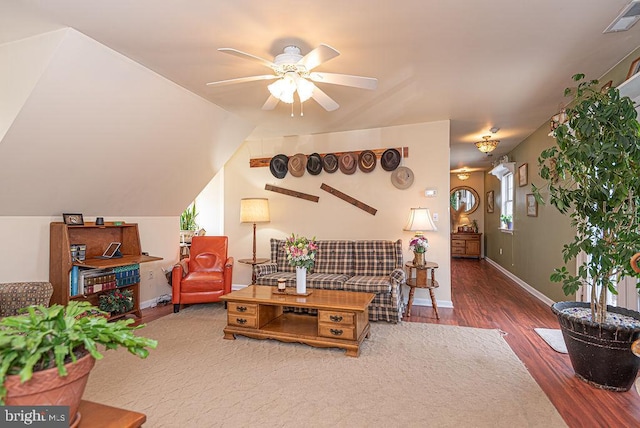 living room with vaulted ceiling, ceiling fan, and dark wood-type flooring