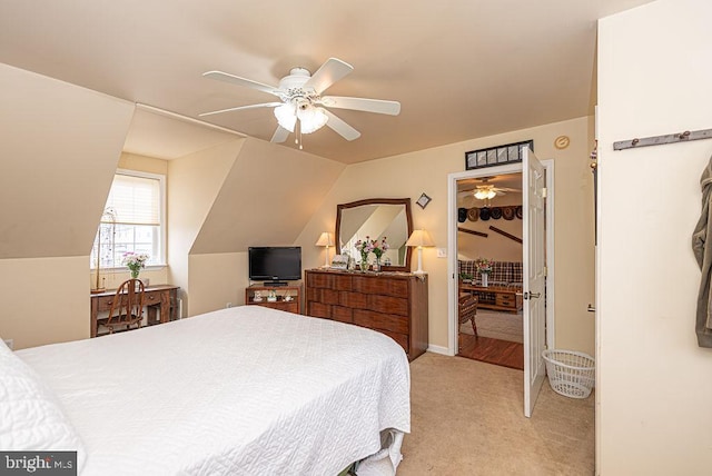 carpeted bedroom with ceiling fan and vaulted ceiling