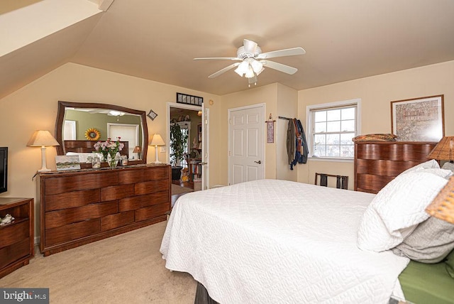 bedroom with ceiling fan, light carpet, and vaulted ceiling