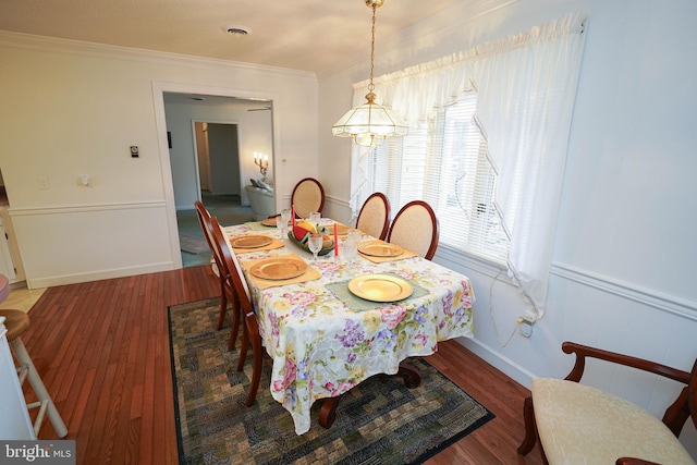 dining area with ornamental molding, wood-type flooring, and a healthy amount of sunlight