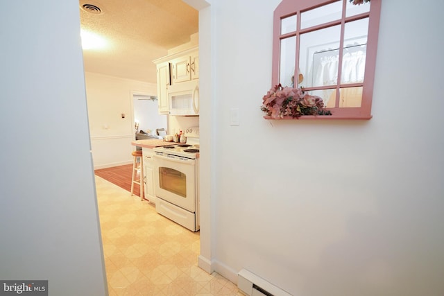 kitchen featuring white cabinets, white appliances, and light tile floors