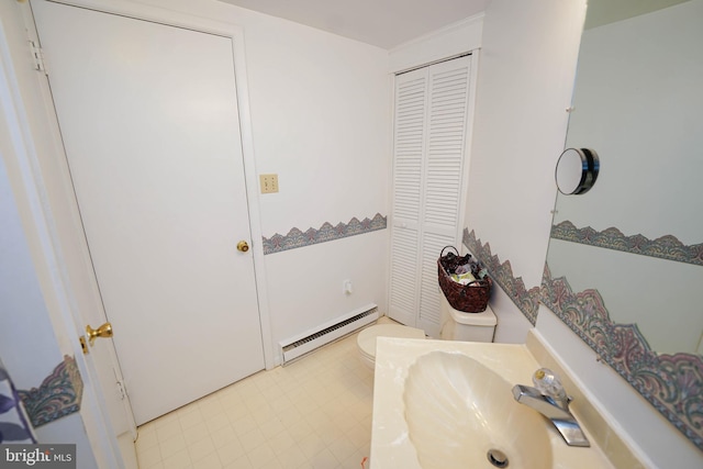 bathroom with a baseboard radiator, sink, tile floors, and toilet