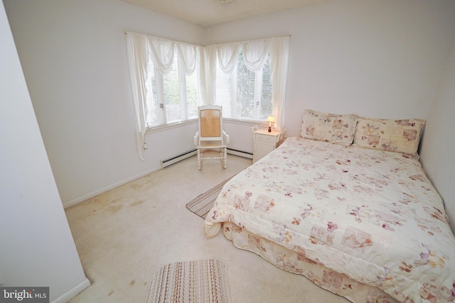 carpeted bedroom featuring a baseboard heating unit