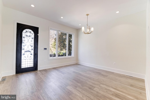 entrance foyer with light hardwood / wood-style flooring and a notable chandelier