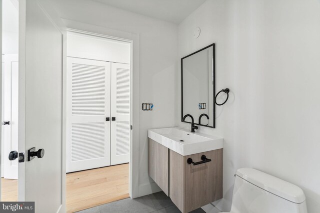 bathroom featuring vanity, toilet, and hardwood / wood-style floors