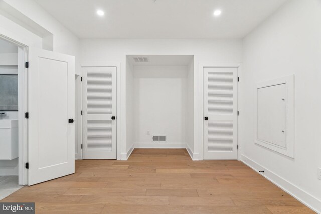 interior space featuring multiple closets and light wood-type flooring