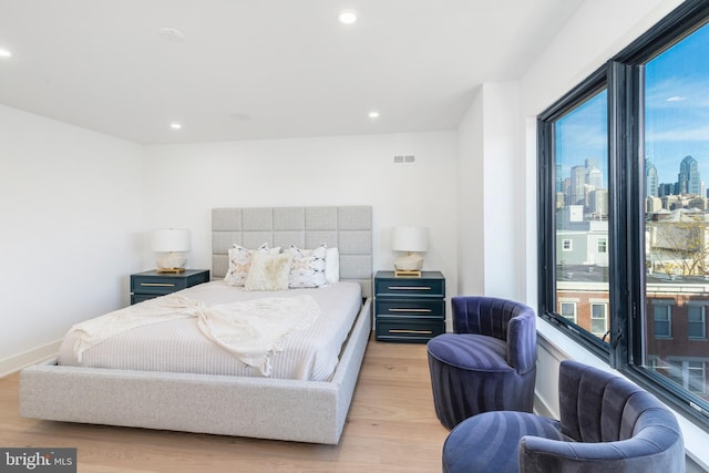 bedroom featuring light hardwood / wood-style flooring and multiple windows