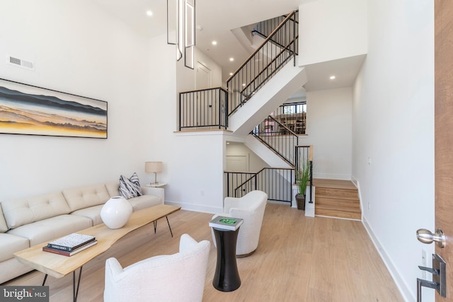 living room with a high ceiling and light hardwood / wood-style floors