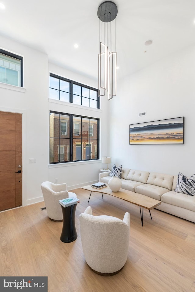 living room with hardwood / wood-style flooring and a high ceiling