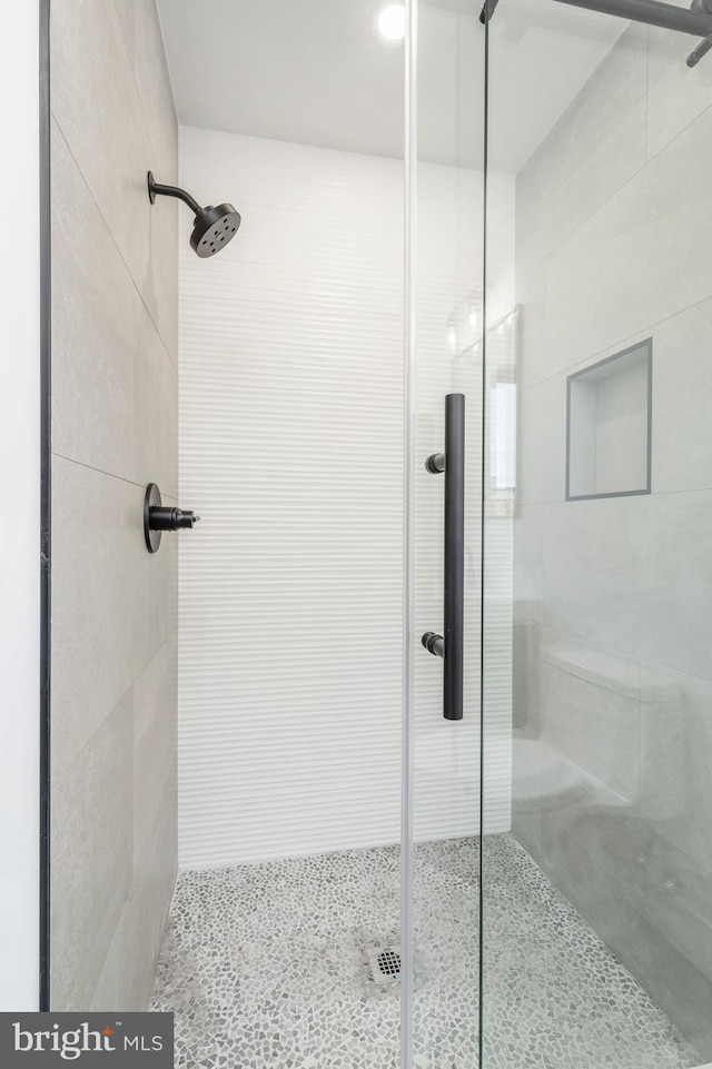 bathroom with a shower with door