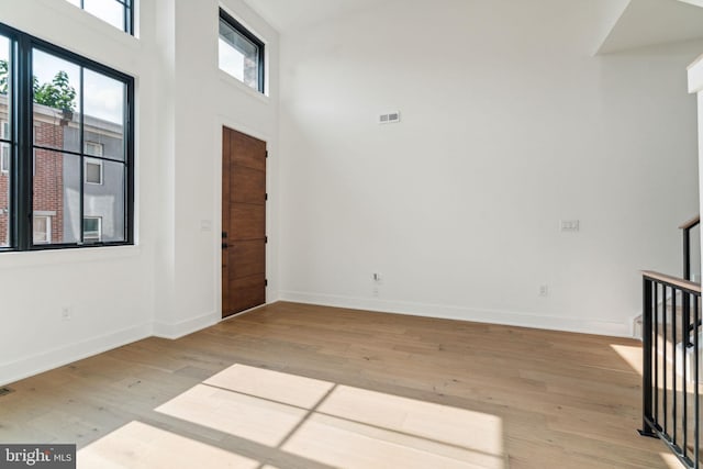 foyer entrance with light wood-type flooring and a high ceiling