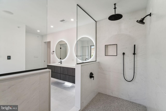 bathroom with vanity and a tile shower