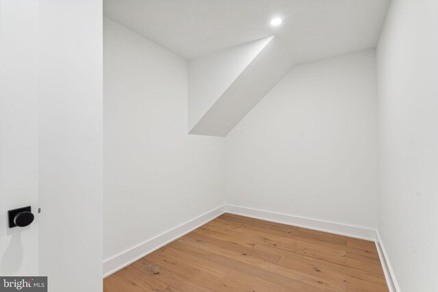 additional living space with lofted ceiling and light wood-type flooring