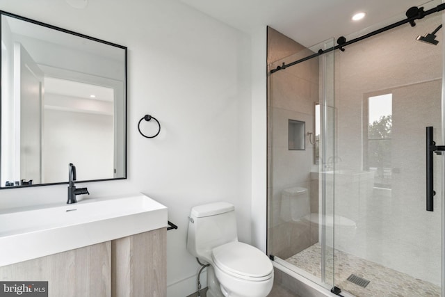 bathroom with vanity, a shower with shower door, and toilet