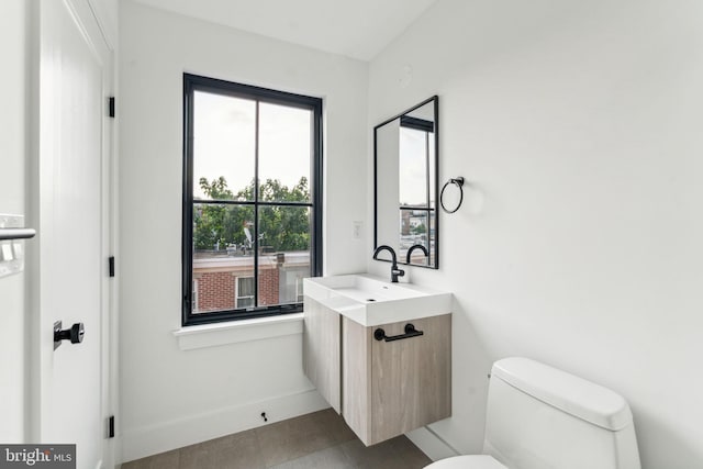 bathroom featuring vanity, tile patterned floors, and toilet