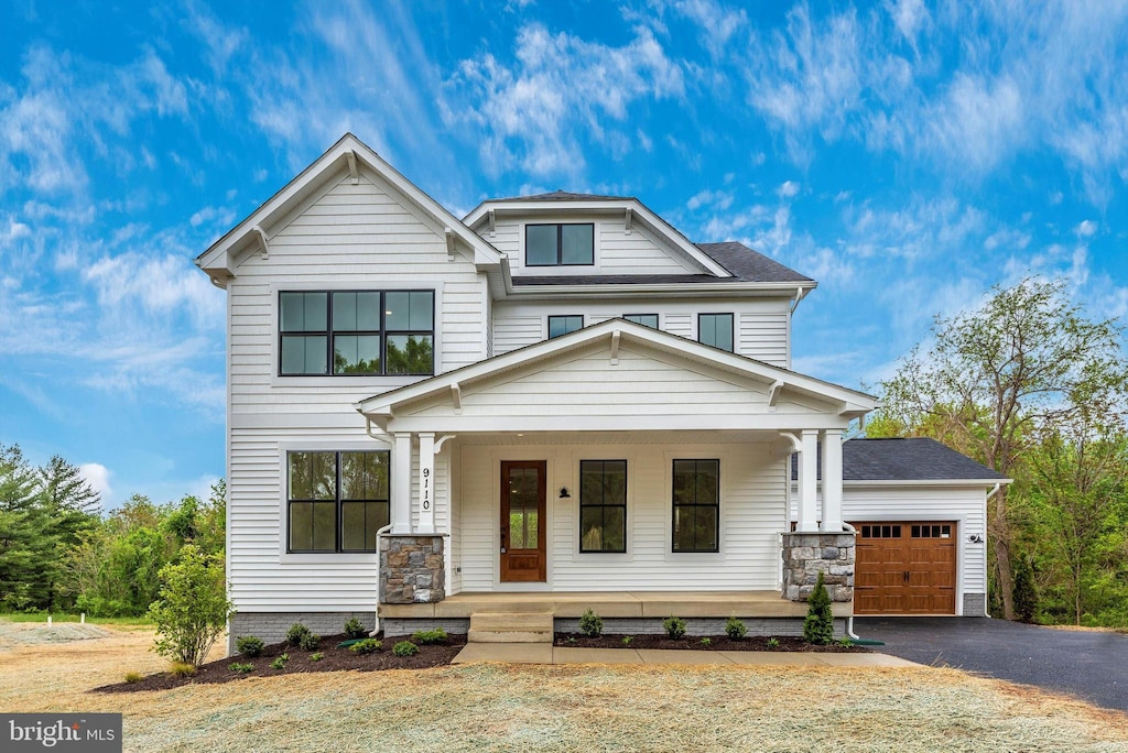 view of front of property featuring covered porch and a garage