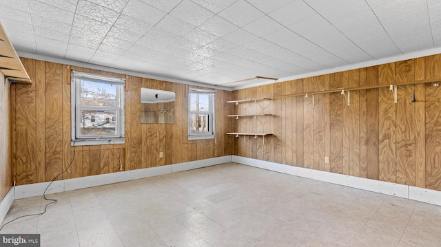 tiled spare room featuring wood walls and a wealth of natural light