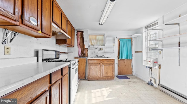 kitchen featuring stove, light stone counters, a baseboard radiator, and sink