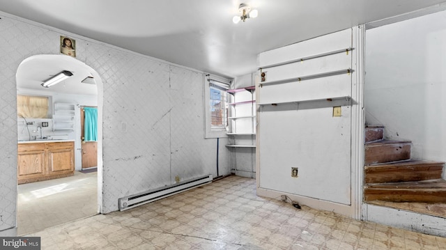 interior space with a baseboard radiator, light tile floors, and sink