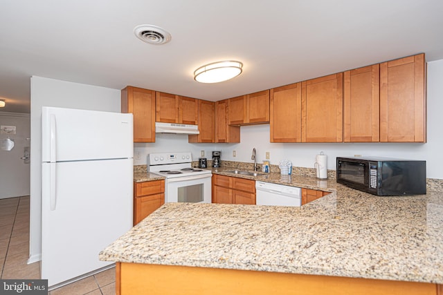 kitchen with kitchen peninsula, white appliances, sink, light tile floors, and light stone counters