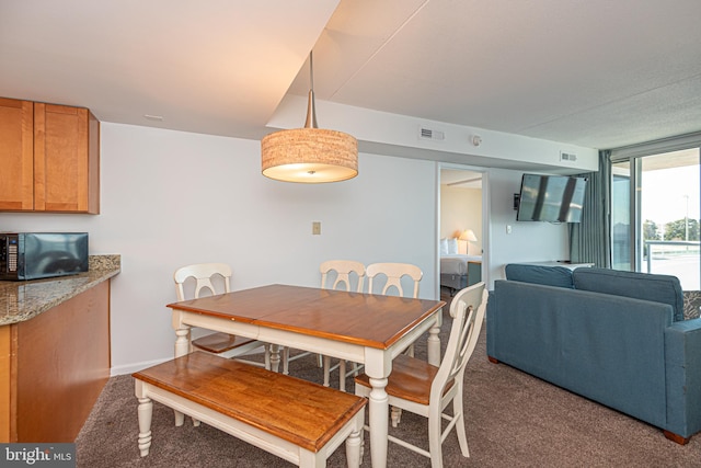 dining area featuring dark colored carpet