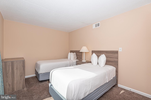 bedroom featuring dark colored carpet and a textured ceiling