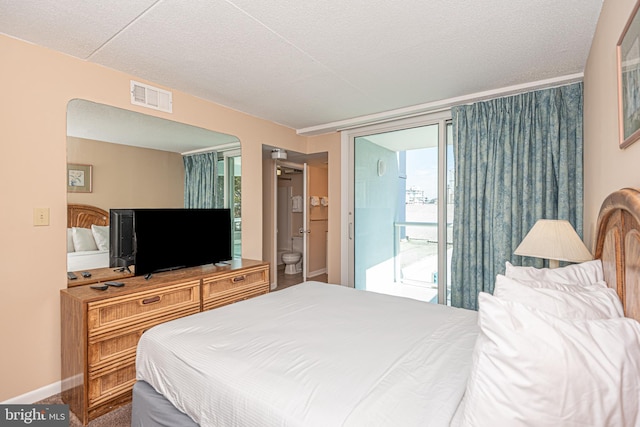 bedroom with access to outside, a textured ceiling, and ensuite bathroom