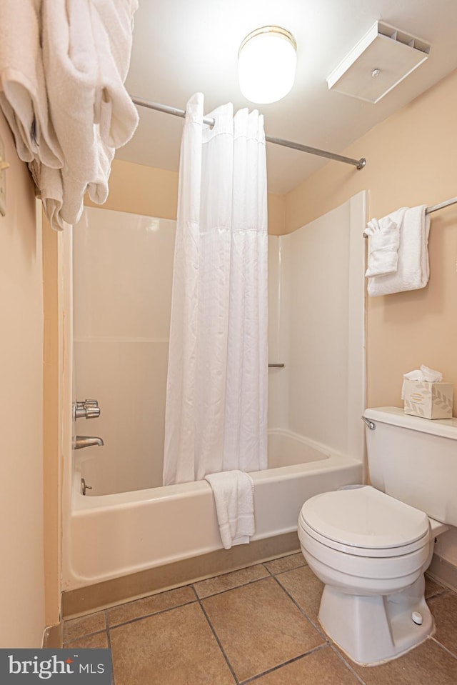 bathroom with tile floors, toilet, and shower / bath combo with shower curtain