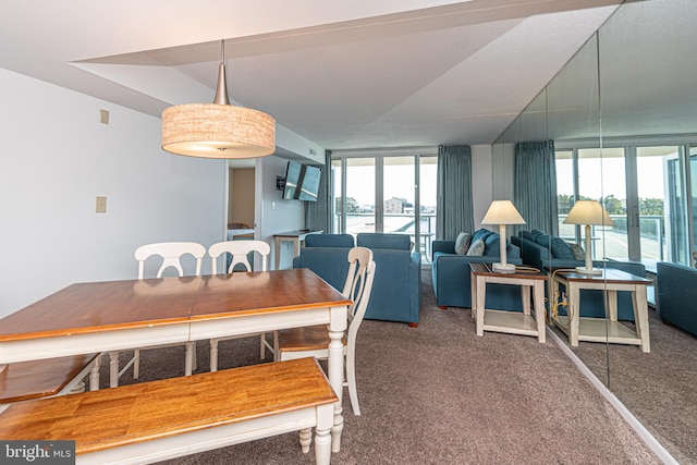 dining room with a water view, dark carpet, and a wealth of natural light