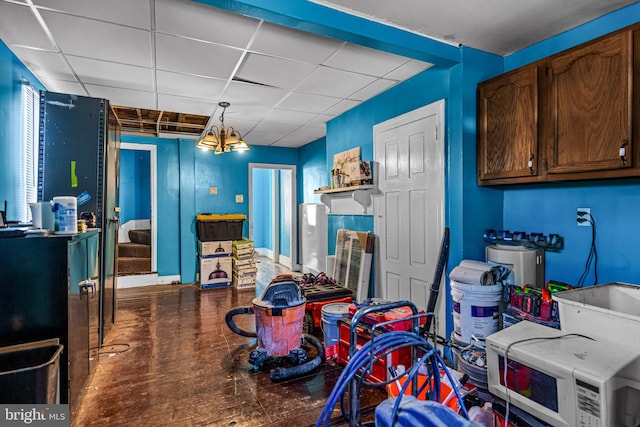 rec room featuring a notable chandelier, a drop ceiling, and dark hardwood / wood-style flooring