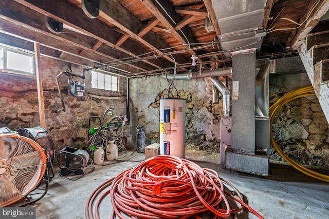 basement featuring electric water heater and a healthy amount of sunlight