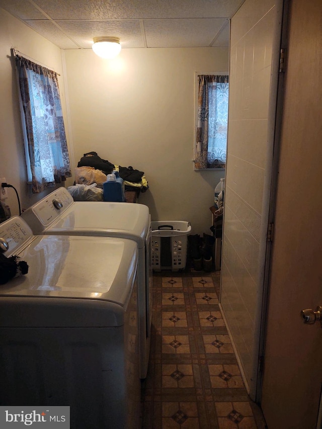 washroom with dark tile floors and washer and dryer