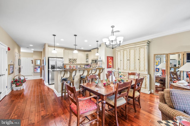 dining room featuring hardwood / wood-style flooring, crown molding, and an inviting chandelier