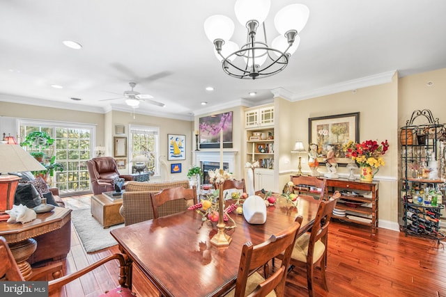 dining room with ceiling fan with notable chandelier, hardwood / wood-style flooring, and crown molding