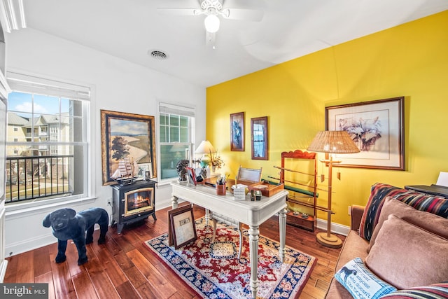 office area featuring a wood stove, dark hardwood / wood-style floors, and plenty of natural light