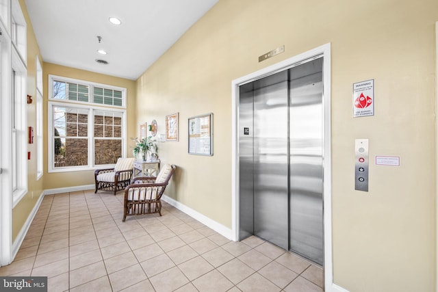 living area featuring elevator and light tile patterned floors