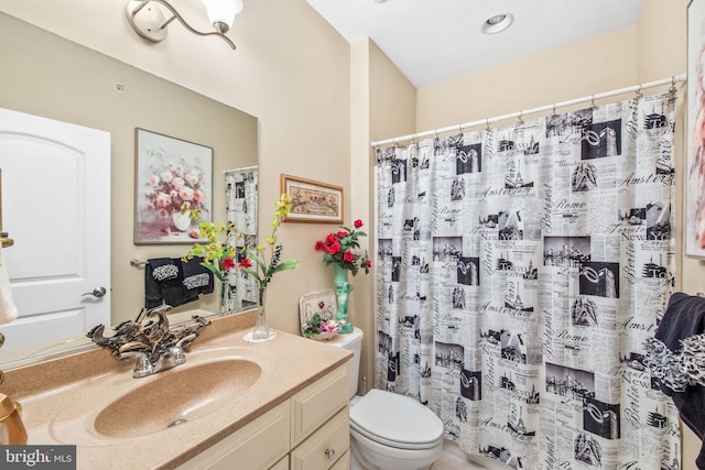 bathroom with curtained shower, vanity, and toilet